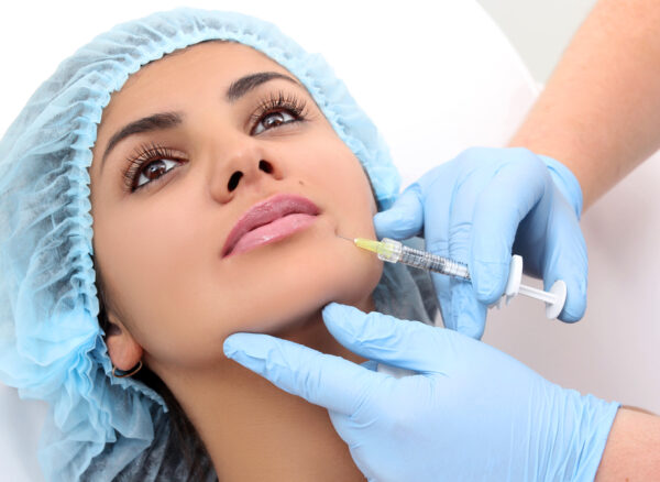 Beautiful woman gets an injection in her lips.